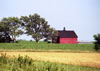 A pastoral landscape is illuminated by a bright red barn